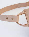A natural, undyed leather fanny pack shoulder bag against a white background.
