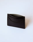 A black leather cardholder sits against a white background. The stitching is visible, as is the "Harper" logo.