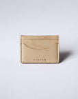 A natural, undyed leather cardholder sits against a white background. The stitching is visible, as is the "Harper" logo.