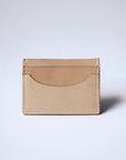A natural, undyed leather cardholder sits against a white background with the back side shown. The stitching is visible.