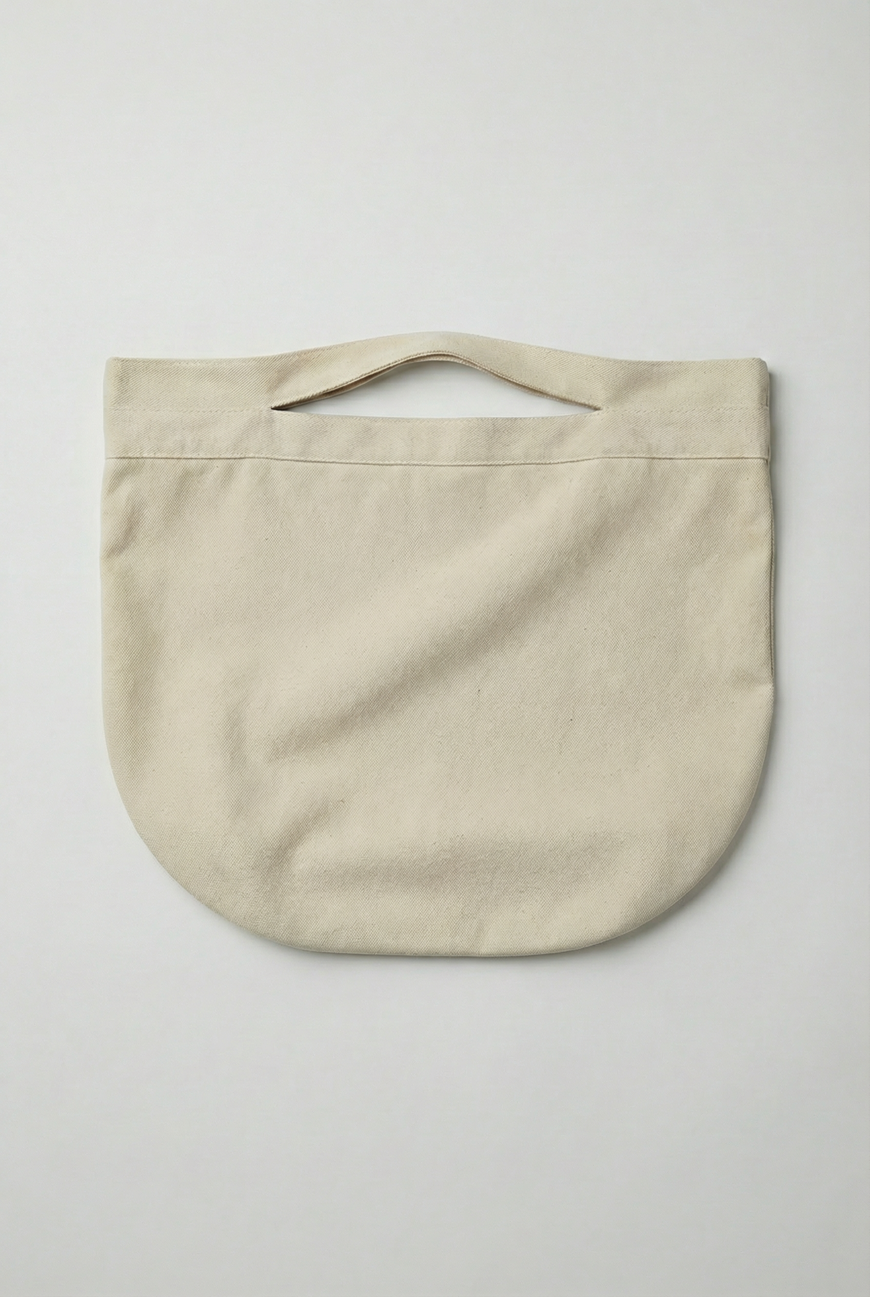 Flat lay of a beige cotton beach bag on a white background