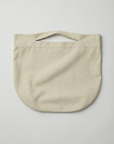 Flat lay of a beige cotton beach bag on a white background