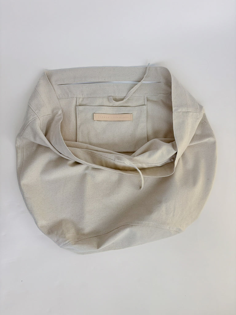 Beige fabric bag with a leather Harper x Mare Perpetua label on a white background