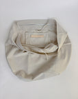 Beige fabric bag with a leather Harper x Mare Perpetua label on a white background